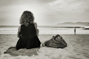 femme-assise-sur-le-sable-au-bord-de-la-plage-1560x1037