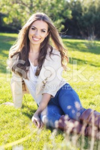 stock-photo-51557748-young-pretty-teenager-girl-sitting-on-green-grass
