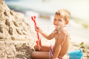 stock-photo-55376046-little-boy-building-a-sandcastle