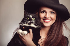 belle-femme-dans-la-robe-et-le-chapeau-noirs-avec-le-chat-66400945