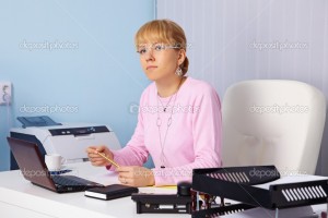 The young serious woman - the chief sits in an office