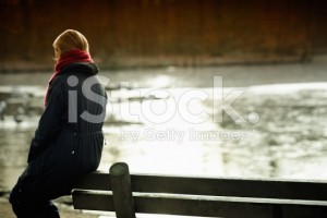 stock-photo-15264902-woman-sits-alone-on-a-bench-across-the-river