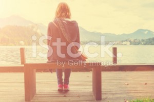 stock-photo-79935625-girl-sitting-on-a-wooden-pier-near-water-