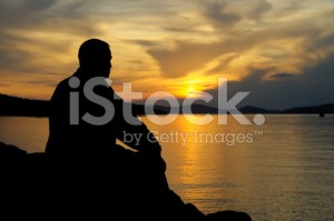 stock-photo-9914372-silhouette-of-a-man-at-sunset-looking-at-the-water