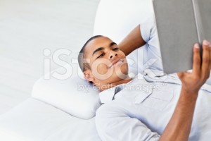 stock-photo-53502058-young-man-reading-a-book-on-the-couch